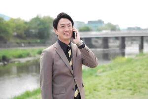 外で電話しているスリーグッド代表 田中祐貴