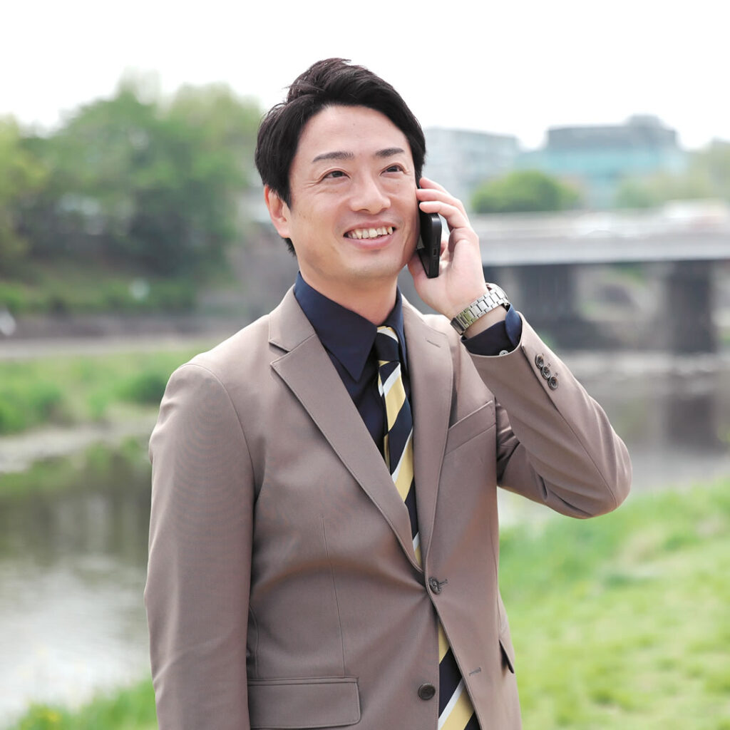 外で電話しているスリーグッド代表田中 祐貴