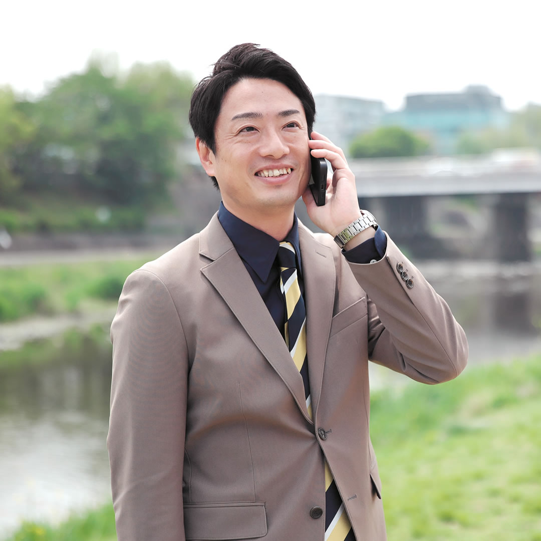 外で電話しているスリーグッド代表田中 祐貴