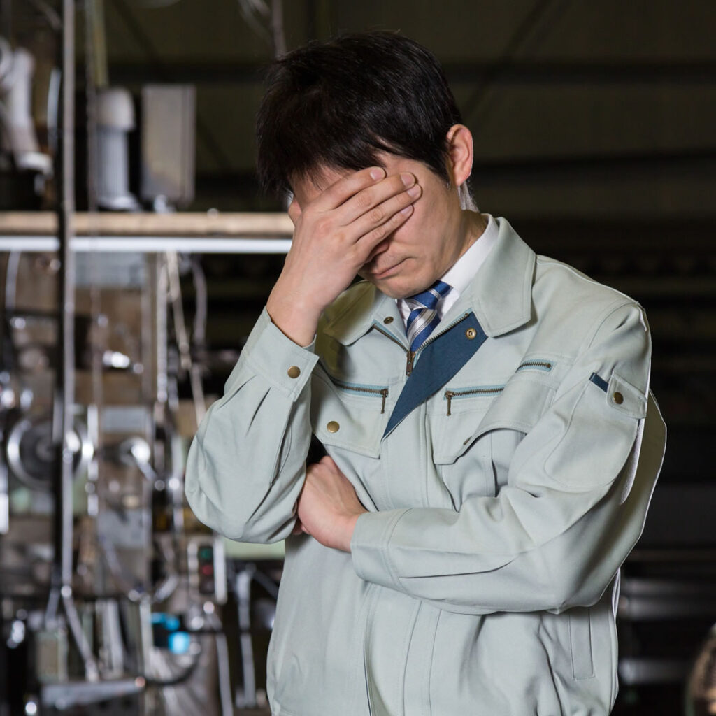 悩んでいる工場勤務の男性